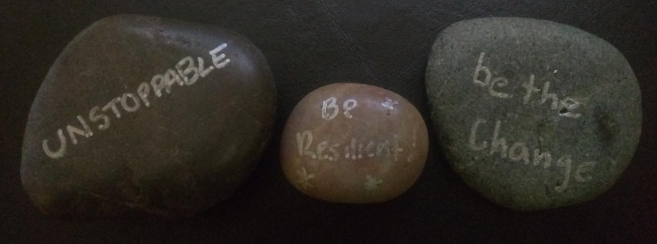 Smooth polished rocks with words painted on them