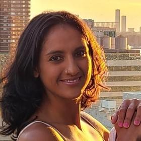 Suneeta Eisenberg standing outside smiling with buildings in background